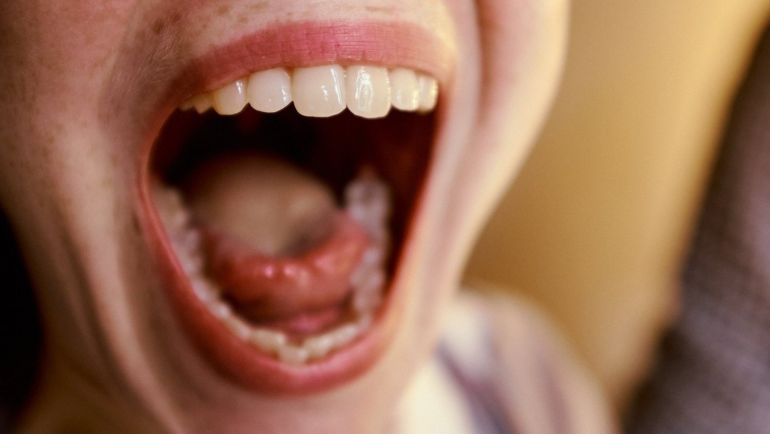 Nahaufnahme eines offenen Mundes, deutliche Sicht auf Zähne und Lippen.