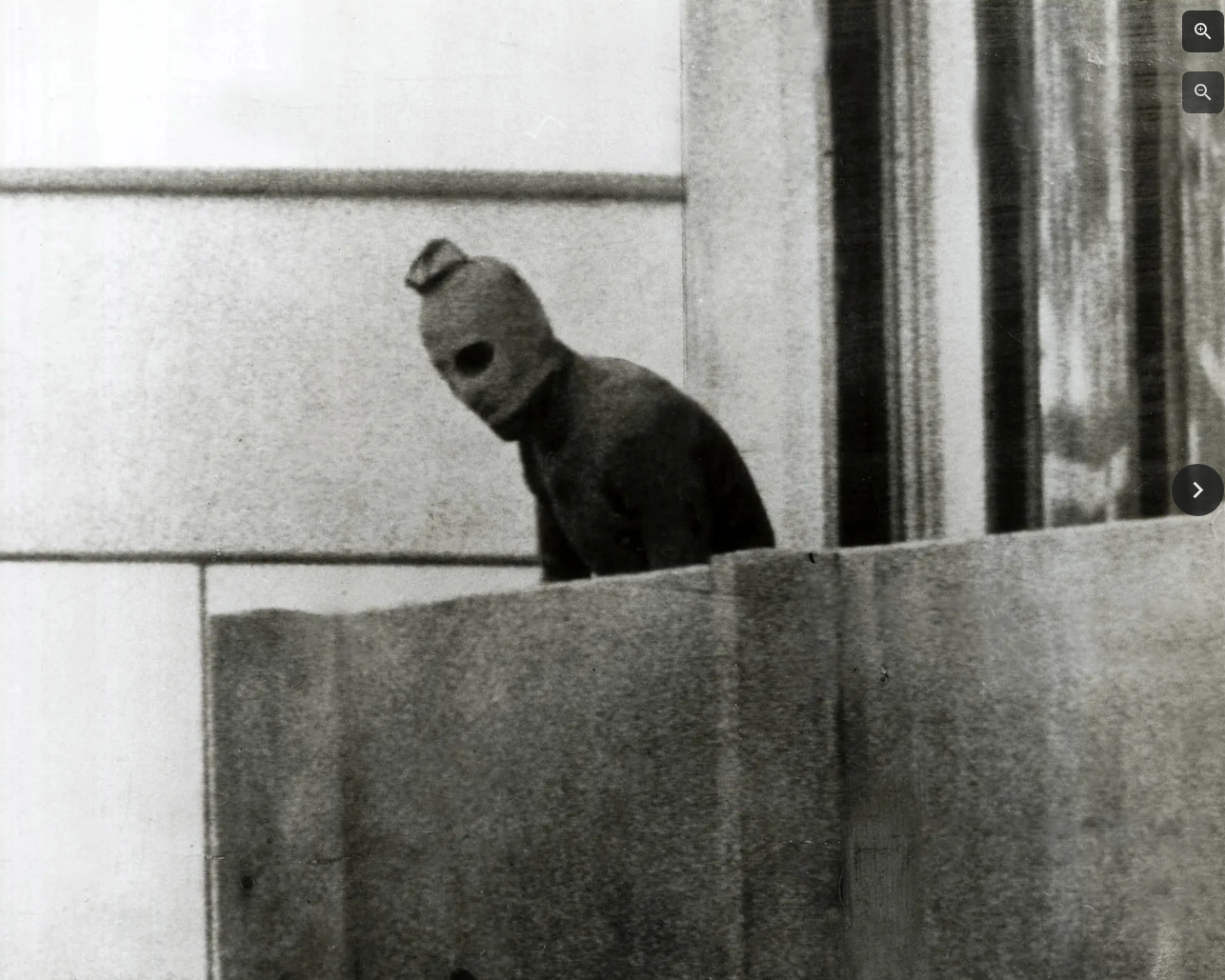 München, Olympische Spiele 1972. Ein palästinensischer Terrorist erscheint auf einem Balkon im Münchner Olympischen…